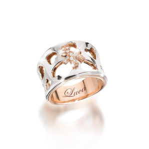 Anello a fascia rastremata
con gambo in oro rosa e fascia a vista in oro bianco cuori traforati maschietto in oro rosa e pavé di brillanti